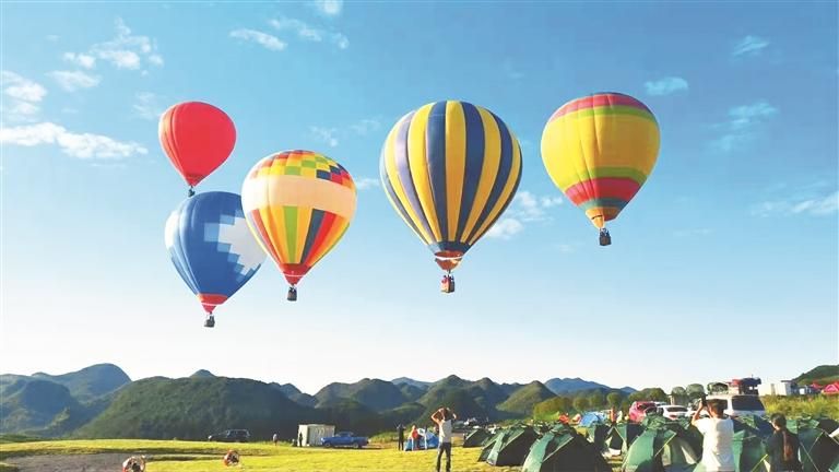 游客在毕节市大方县崔苏坝露营基地体验热气球